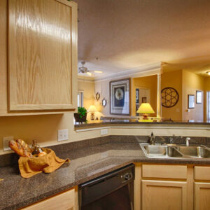 Apartment kitchen with updated countertops that opens into living room - The Legends Apartments