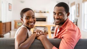 smiling couple sitting on couch