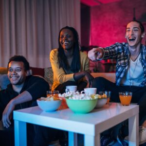Three friends watching a movie together with popcorn