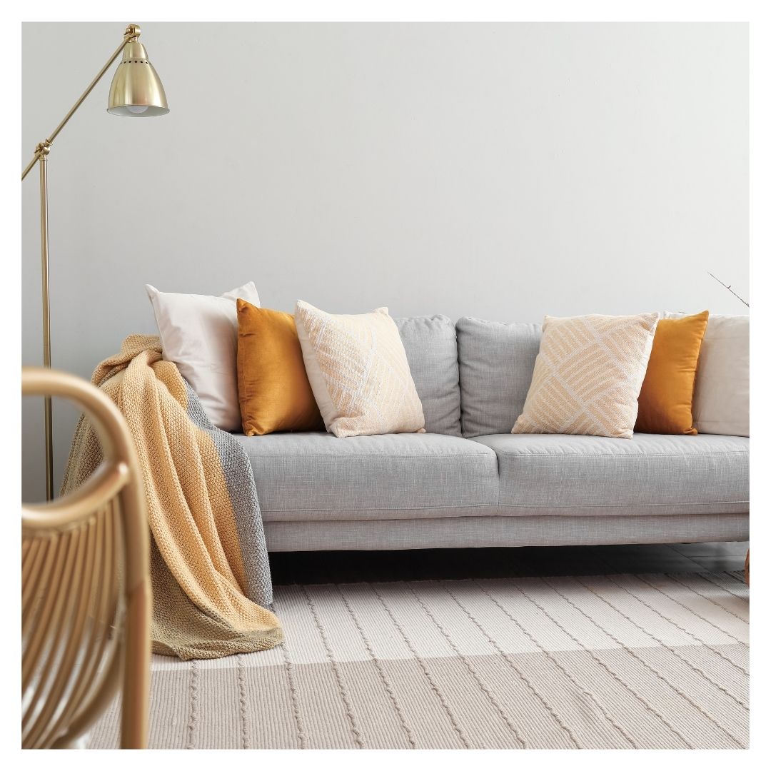 couch with orange pillows and a throw