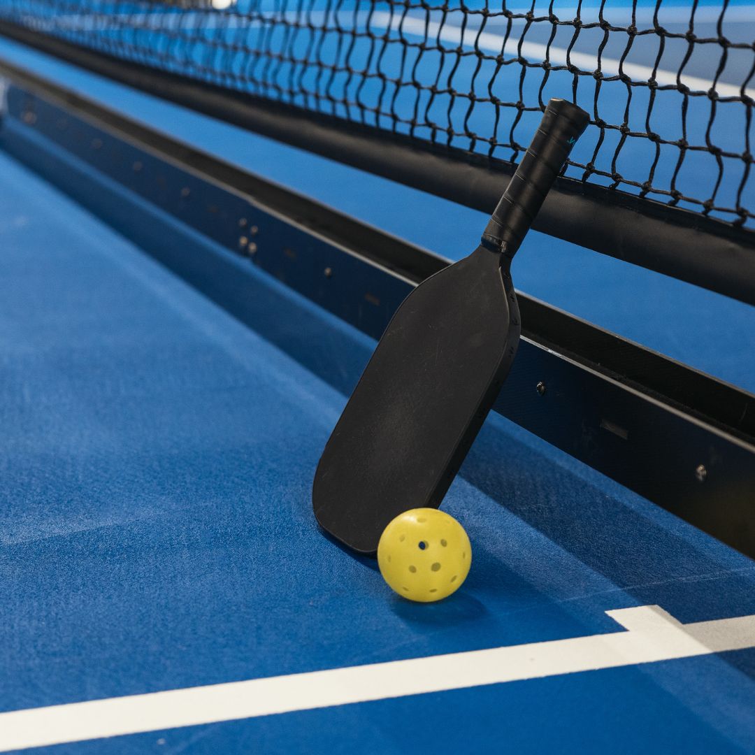 pickle ball paddle and ball on court